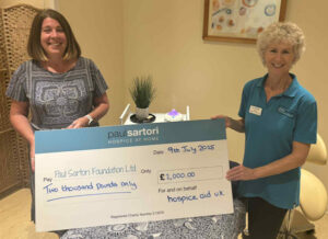 staff from paul sartori hospice at home with a cheque from hospice aid uk