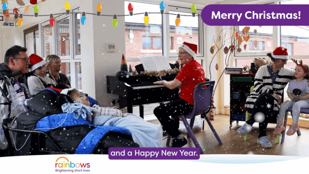 Christmas scene at a children's hospice. Rainbows hospice staff with Santa hats, playing a piano and singing with children and their parents